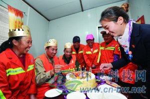 社区工作人员为集体过生日的三名环卫工人点上生日蜡烛。 本报通讯员 赵松 摄